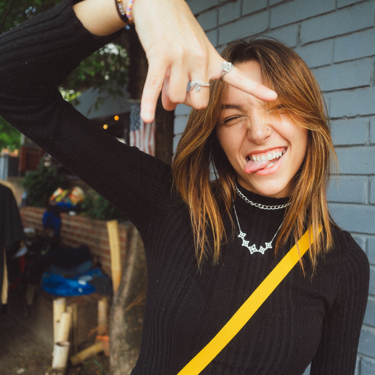 Street portrait, smiling person gesturing at the camera