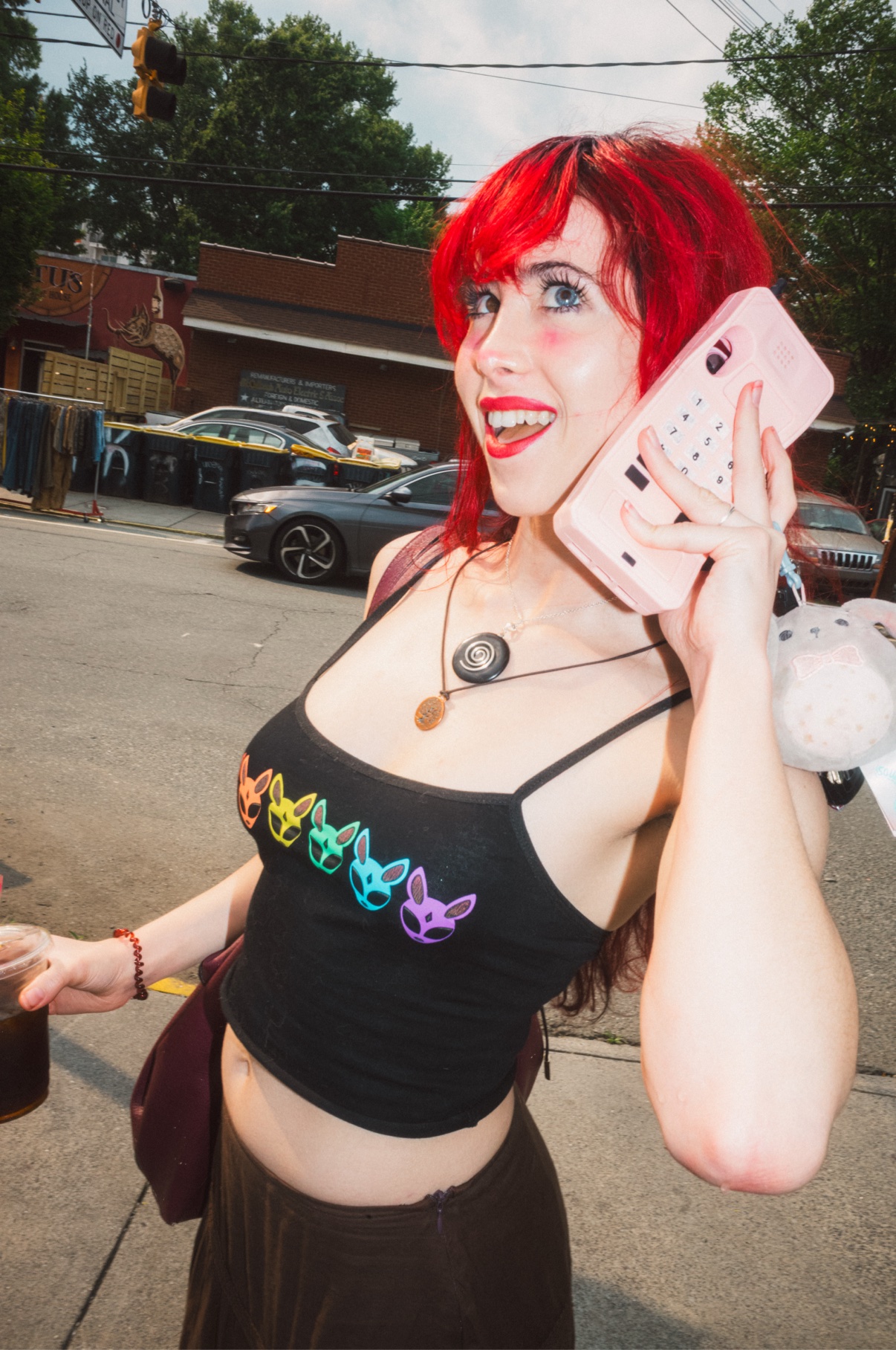 Street portrait, person with red hair holding a pink phone